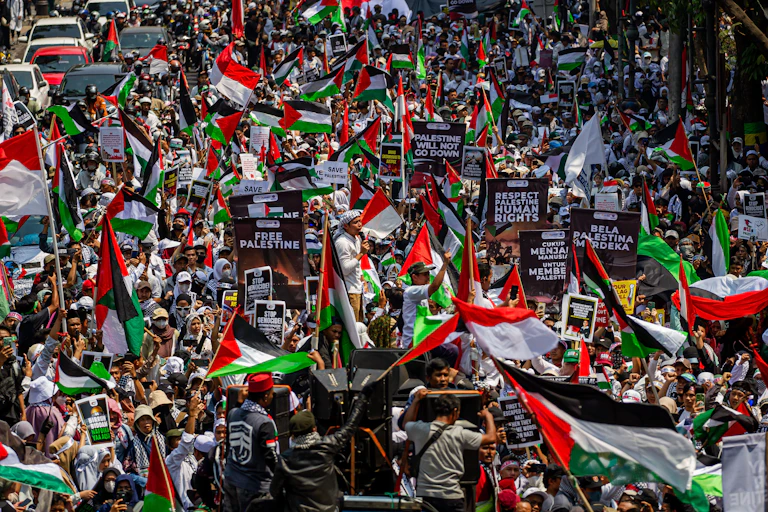 Foule brandissant drapeaux palestiniens et pancartes