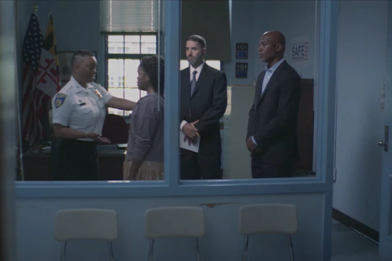 A group of officers meet with a student in school.