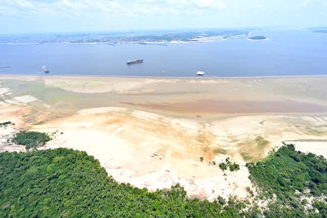Imagem de um banco de areio nas margens de um rio com fluxo reduzido na Amazônia