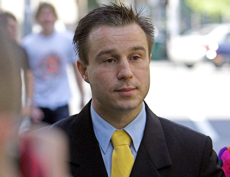 A man in a suit and a yellow tie