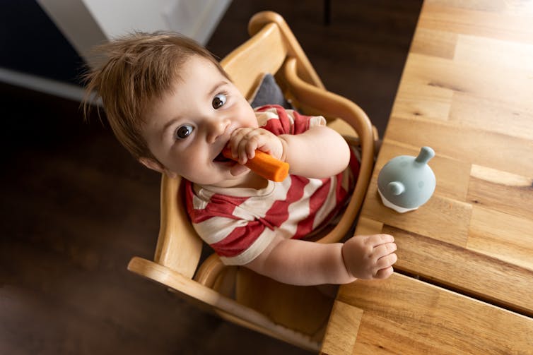 Young boy eating a carrot