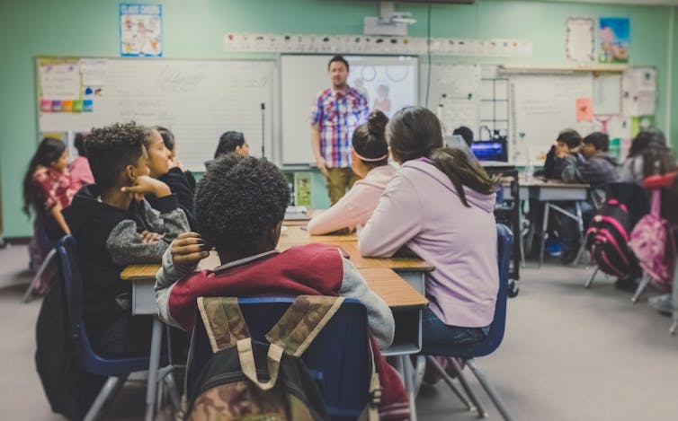 Students in a classroom with a teacher.