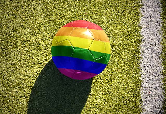 A football in rainbow colours on a pitch