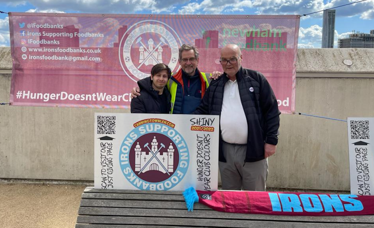 Three men holding a banner about food poverty