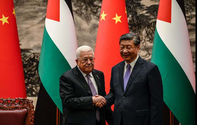 Two men shake hands in front of Chinese and Palestinian flagshttps://www.gettyimages.com/detail/news-photo/chinas-president-xi-jinping-shakes-hands-with-palestinian-news-photo/1258685965?adppopup=true