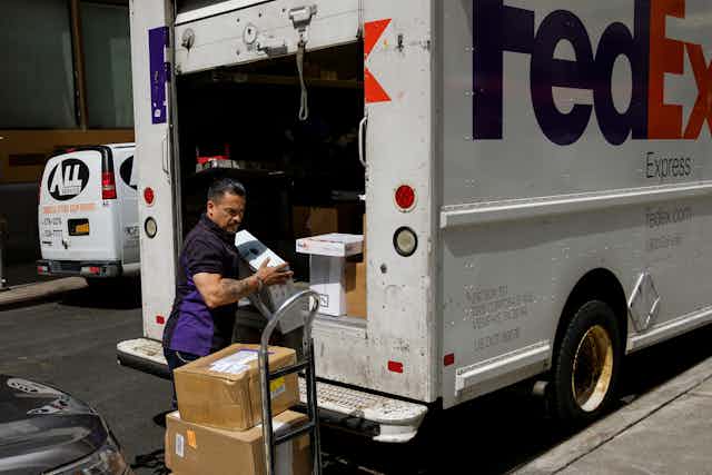 A FedEx delivery driver unloads packages from his truck in Lower Manhattan.