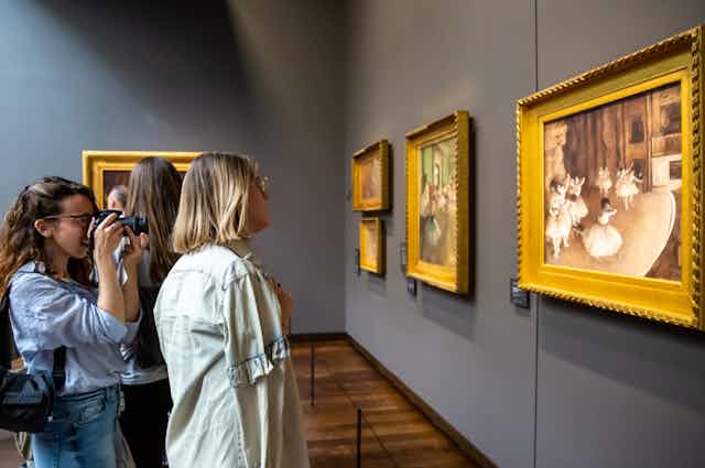 women looking at works in a museum