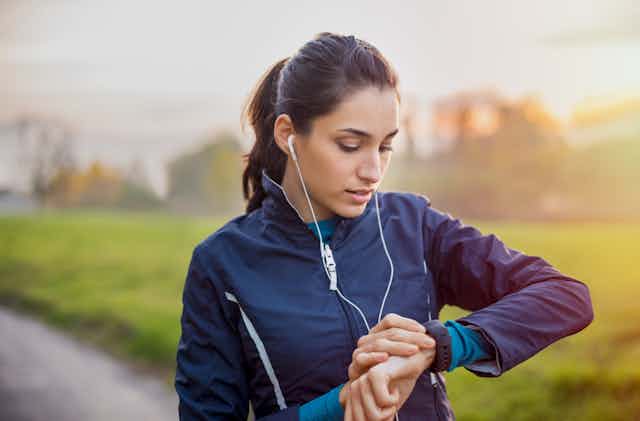A woman runs while listening to music and wearing a connected watch
