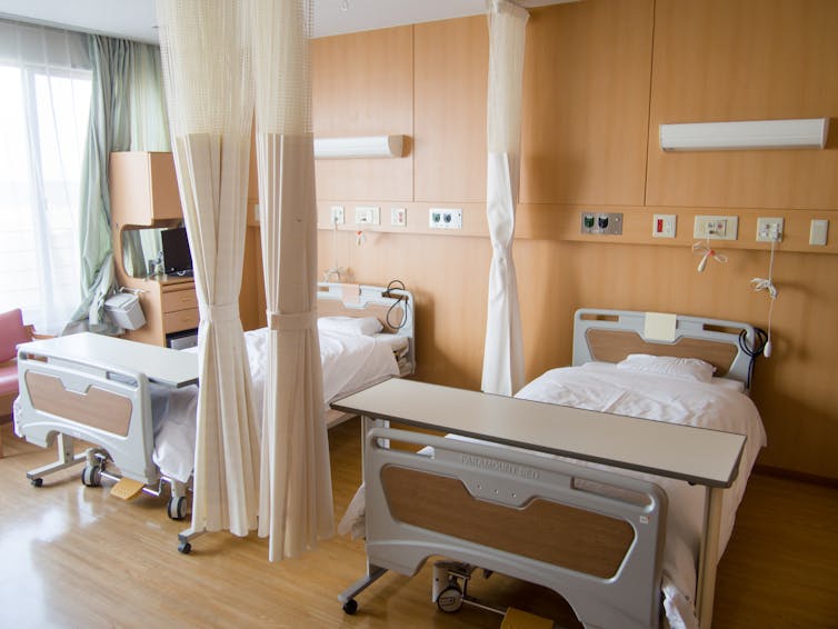 Hospital beds separated by curtains