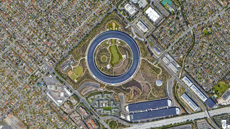 A very large circular building with greenery around it viewed directly from above