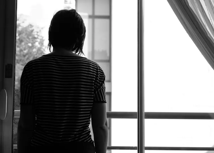 A woman looking out a window.