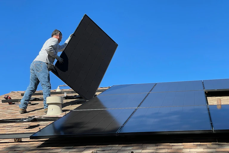 Man installing rooftop solar panels