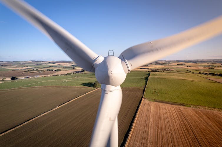 A close-up shot of a wind turbine in a field.