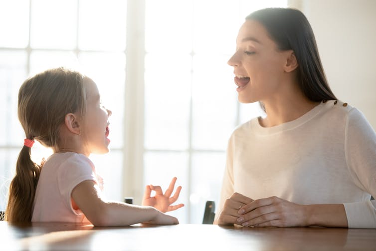 Speech therapist showing young patient how to roll tongue in forming a word