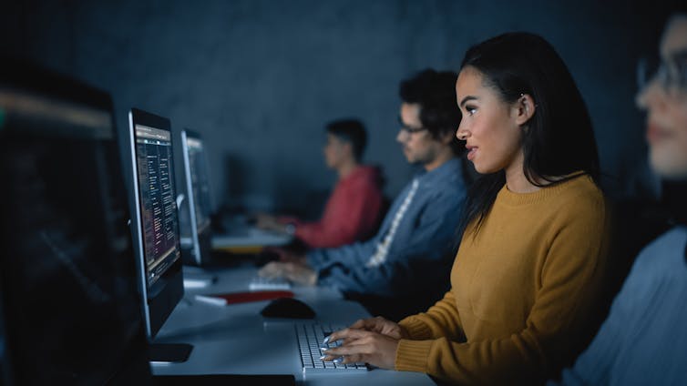 A woman sitting at a keyboard.