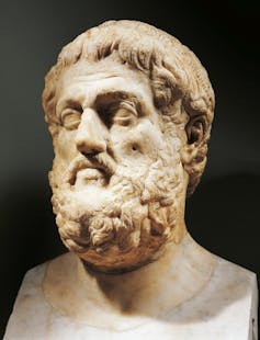 A marble sculpture of the head of a bearded white man.
