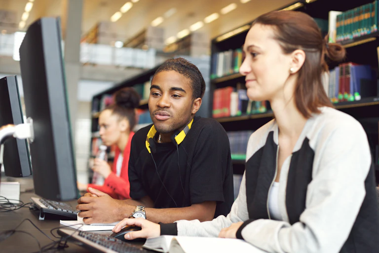 Two people seen at a computer.
