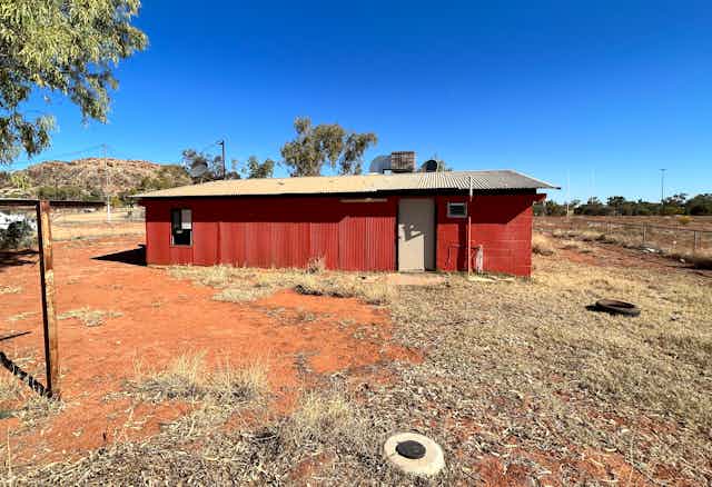 A small corrugated iron house in the Australian outback