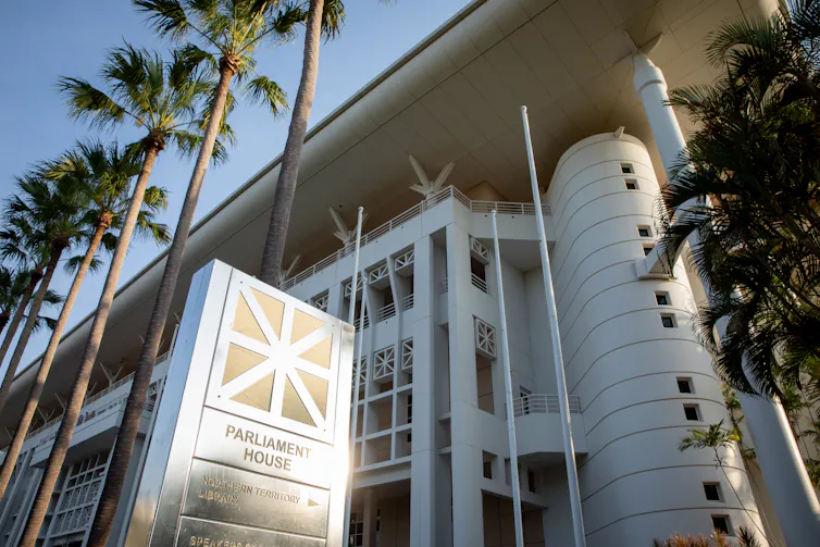A look up from the ground at the NT Parliament House sign and building in Darwin