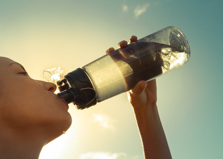 woman drinks from bottle
