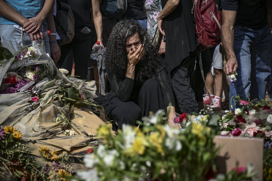 Femme en larmes accroupie pendant un enterrement