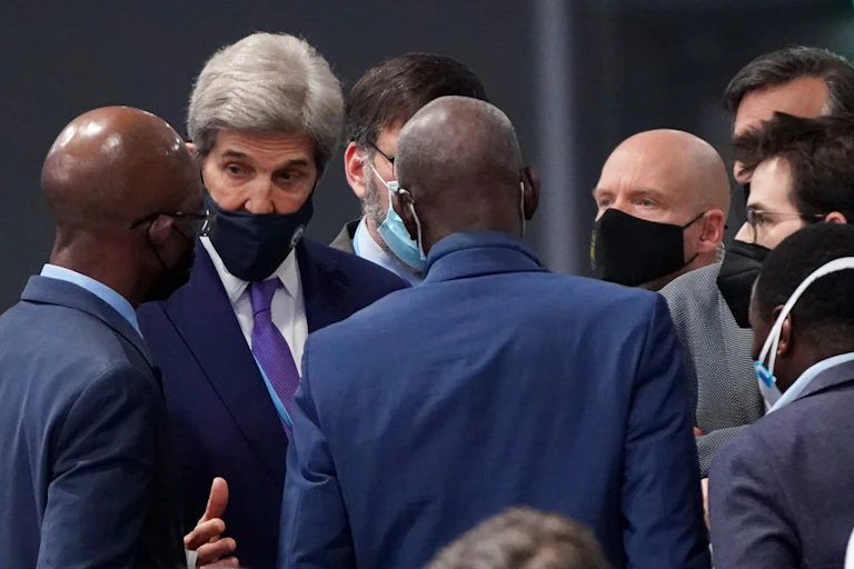A group of people from different countries are speaking, with John Kerry in the middle.