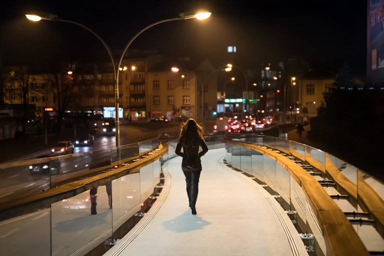 A woman walks in a city in the dark