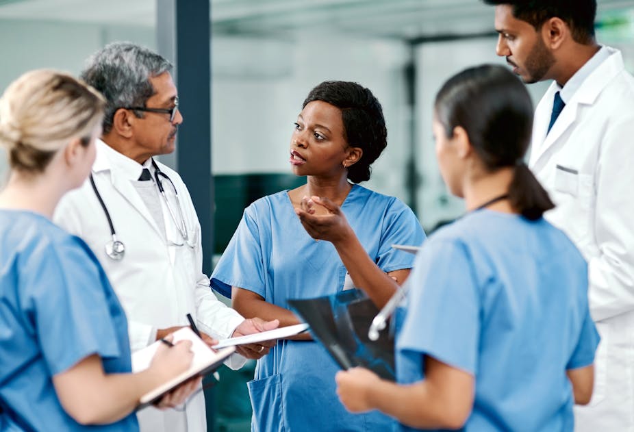 A photograph of a group of medical practitioners having a discussion in a hospital