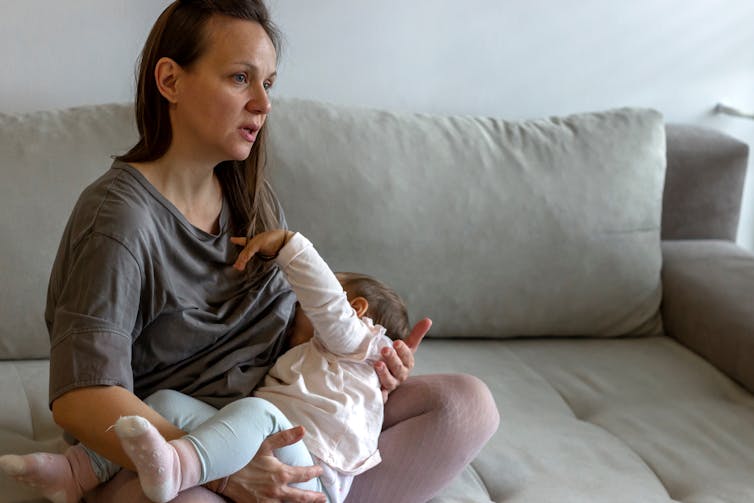 Woman breastfeeding on sofa