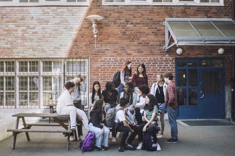 students sitting on picnic table