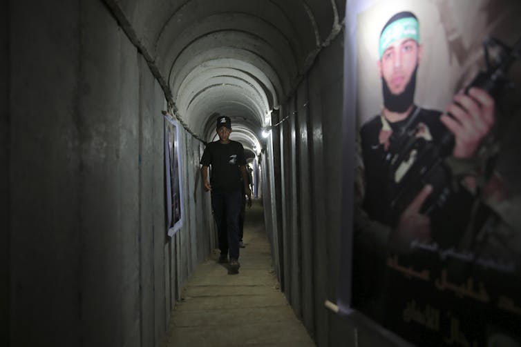 A person walks through a concrete tunnel.