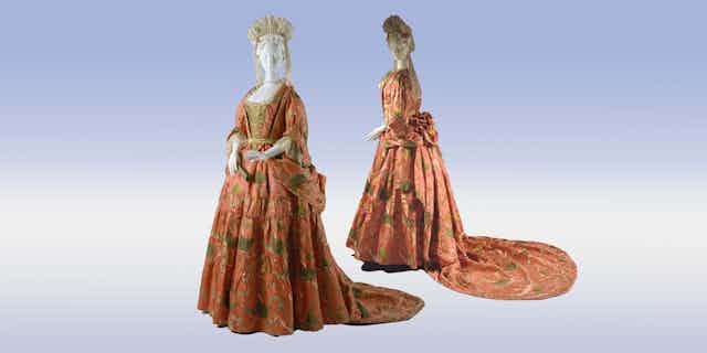 Two mantuas are displayed showing the distinctive coat over the skirts, with pleating and draping.