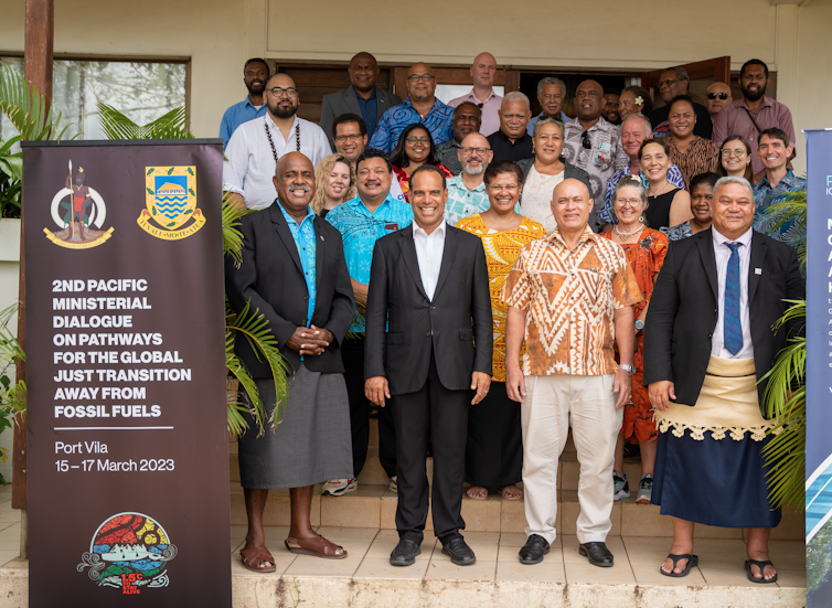 Pacific Island ministers meet at the harbor villa.  group of people standing in front of a photo.