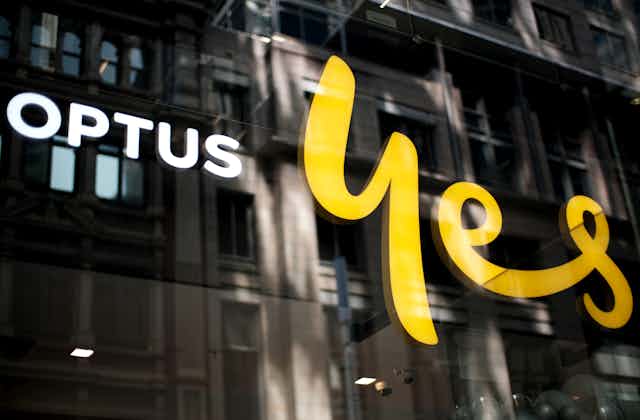 A glass window with Optus logo and the word yes in yellow script