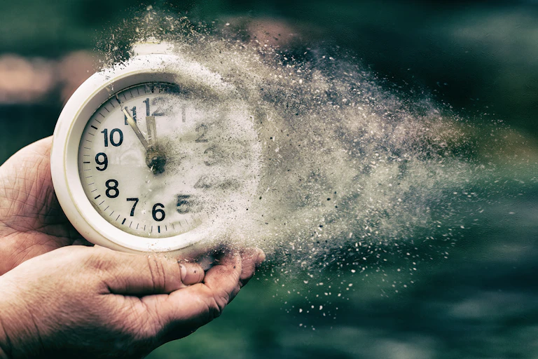 Retro alarm clock dissolving into little pieces