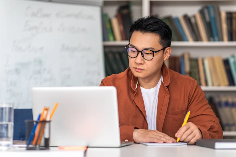 Man talking notes from laptop