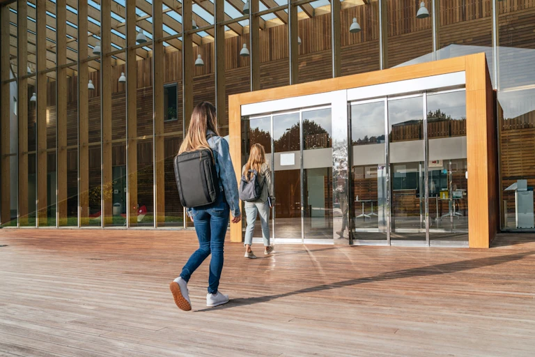 Deux étudiantes se dirigeant vers l'entrée d'une université