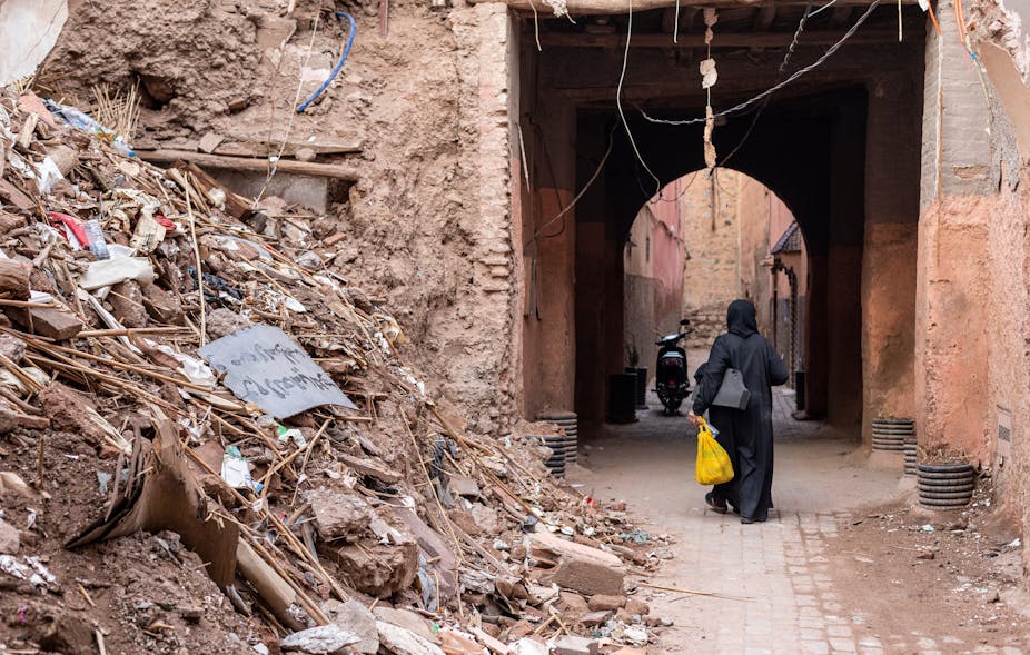A woman walks past a pile of rubble in Marrakech's old medina. 