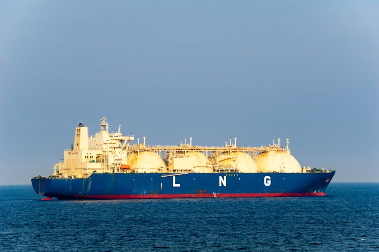 A large LNG tanker with 4 LNG tanks sailing along the sea.