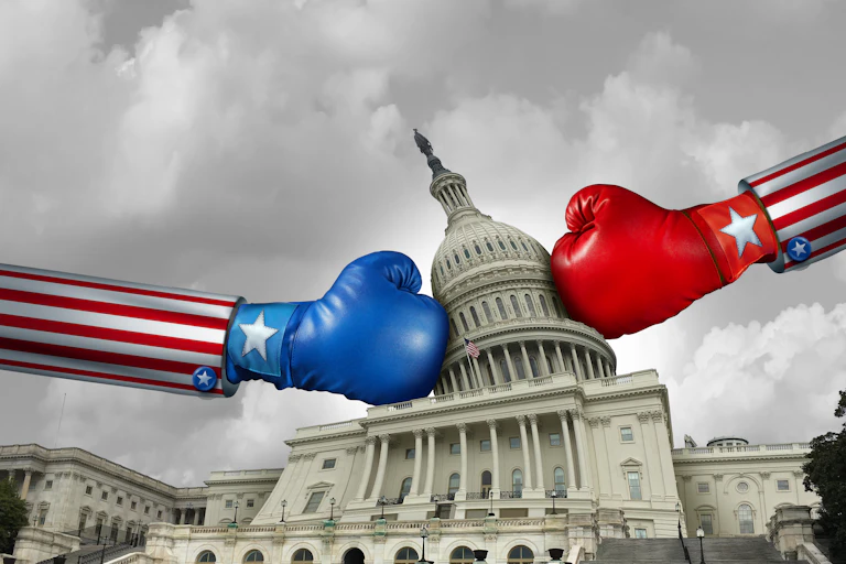 A blue boxing glove and a red boxing glove come from opposite sides of the US Capitol building, twisting the building's dome.
