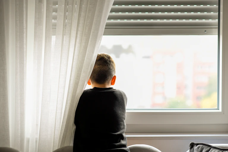 young boy looking out of window