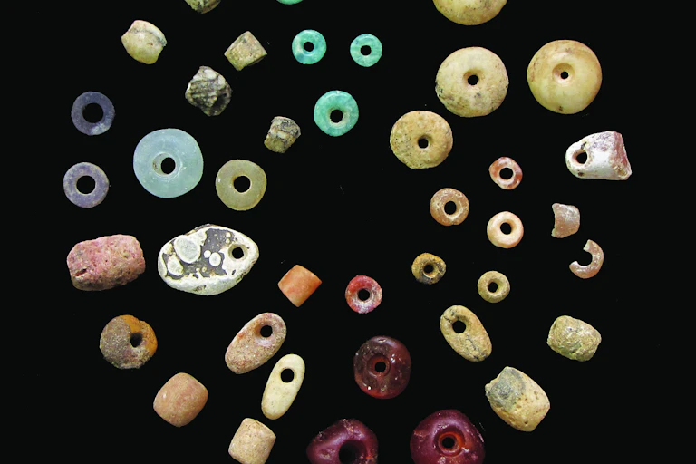 Colourful beads of different shapes on a black background