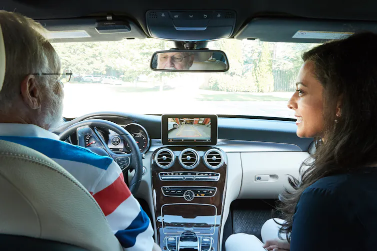 an older driver and a younger passenger in a car