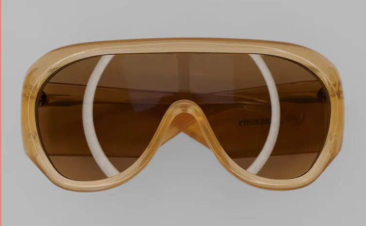 A pair of gold 1970s style sunglasses.