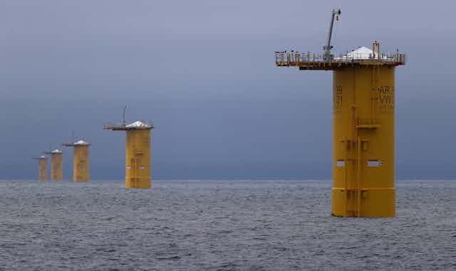 Five round yellow towers stand in open ocean waters