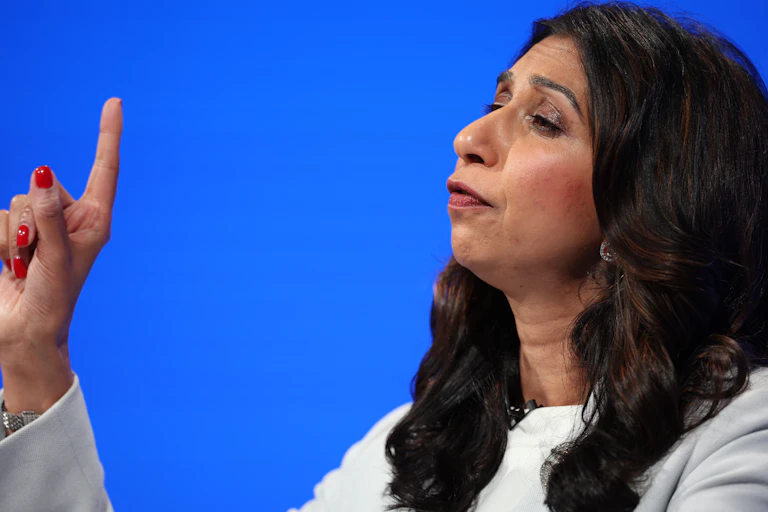 Suella Braverman holding up an index finger as she delivers a speech.