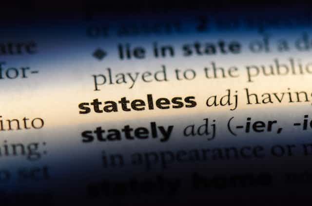 A close-up of the word 'stateless' in the dictionary