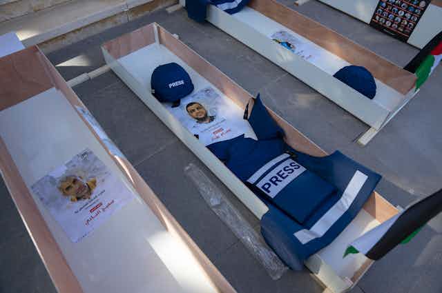 Imágenes de personas colocadas en ataúdes para destacar la muerte de periodistas