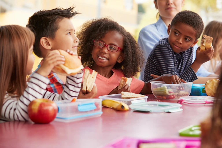 group of kids sit at lunch table
