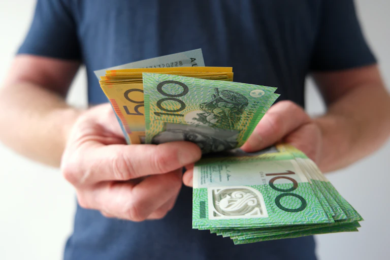 Unidentified man holding dozens of hundred dollar and fifty dollar notes